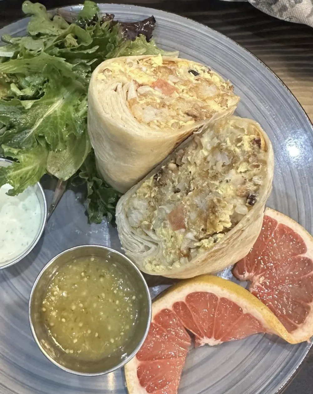 Breakfast burrito with salad, salsa, and grapefruit