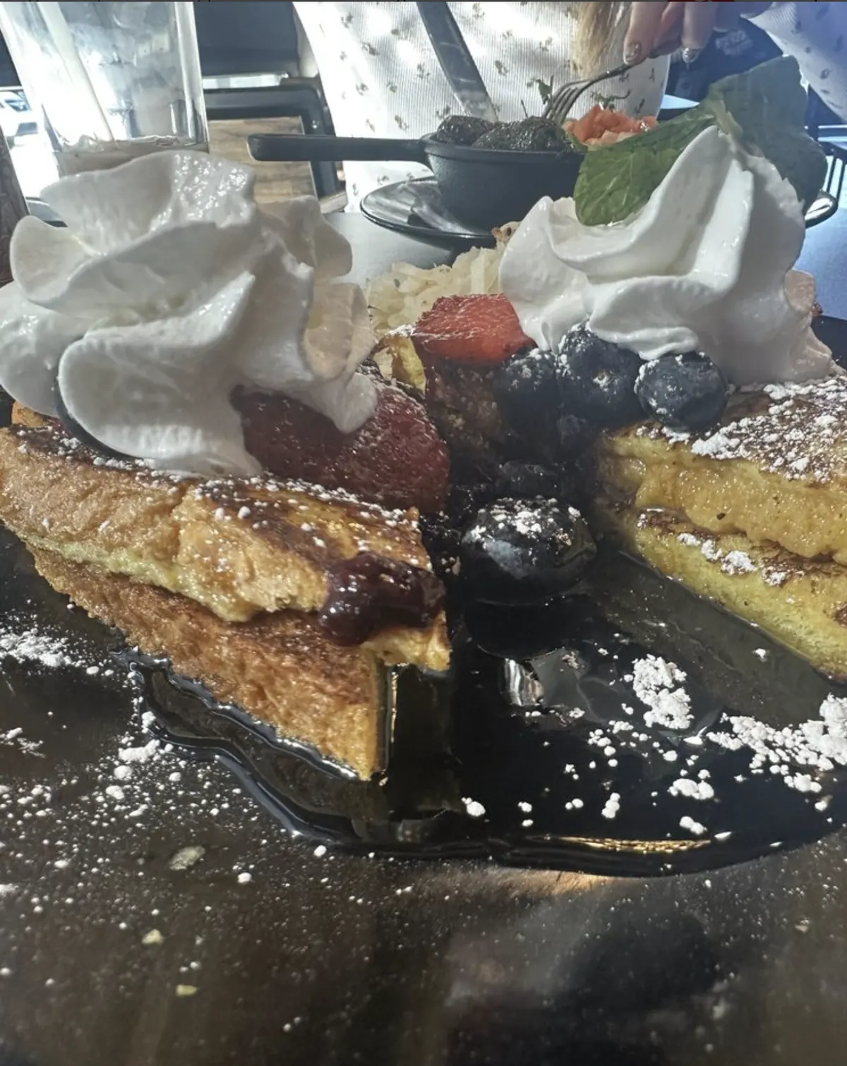 French toast with berries, whipped cream, and powdered sugar at Urban Kitchen